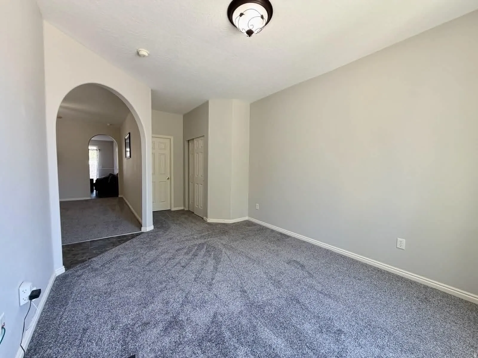 Spacious room featuring gray carpeting and light gray walls