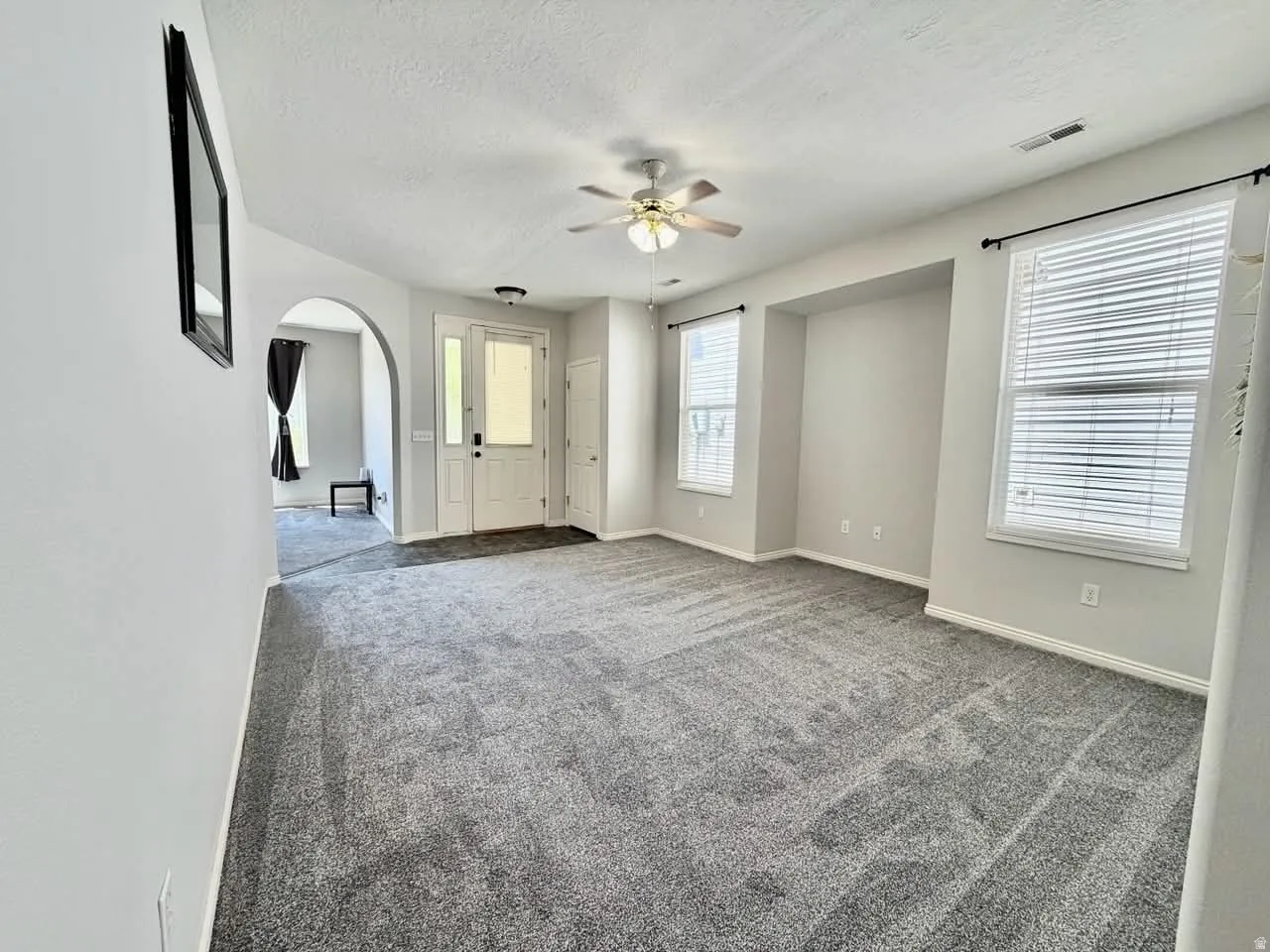 Spacious interior featuring neutral gray carpeting and light gray wall paint