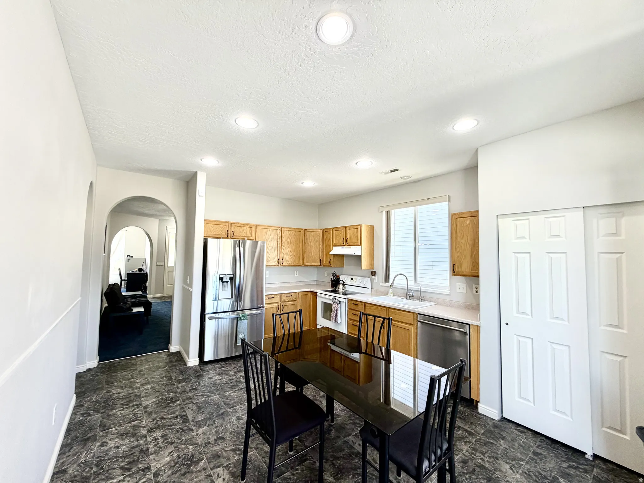 Kitchen featuring wood cabinetry, stainless steel appliances, and a double-basin sink