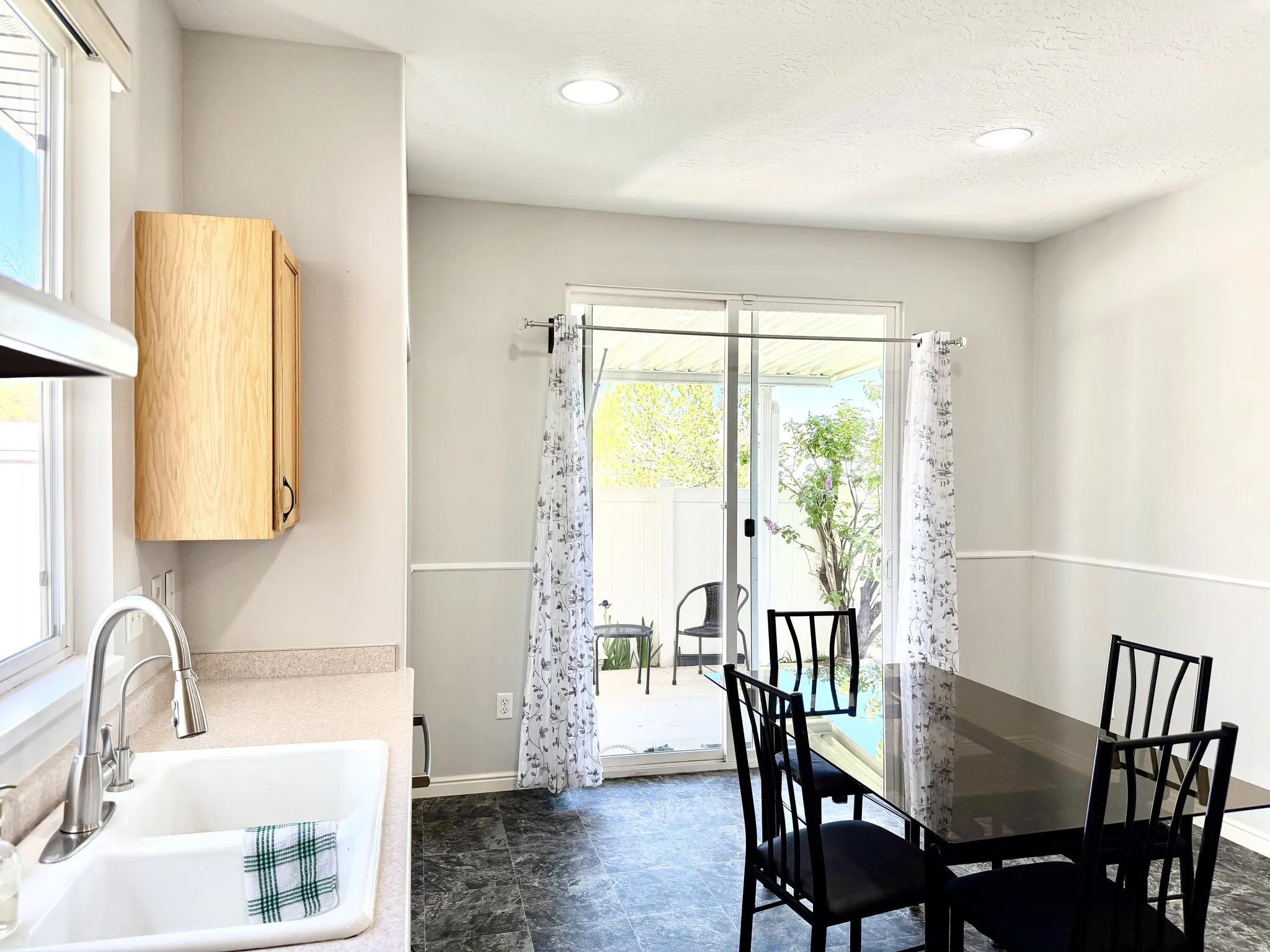 Dining area featuring sliding glass doors to a patio, recessed lighting, and chair rail molding