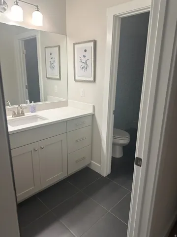 Bathroom featuring vanity and dark tile patterned flooring