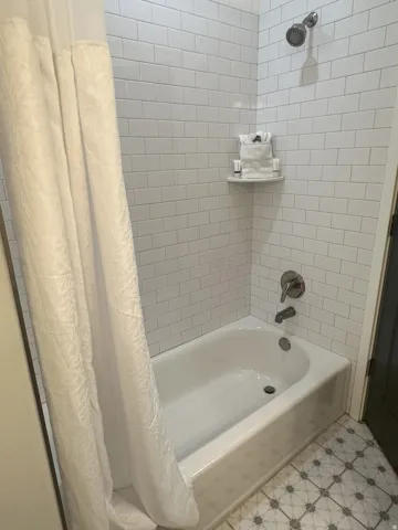 Bathroom with light floors and shower / bath combo