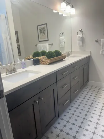 Bathroom featuring double vanity and light flooring