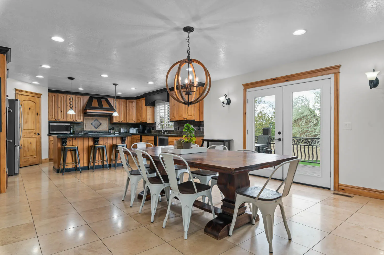 Dining room with light tile patterned floors, french doors, and suspended lighting