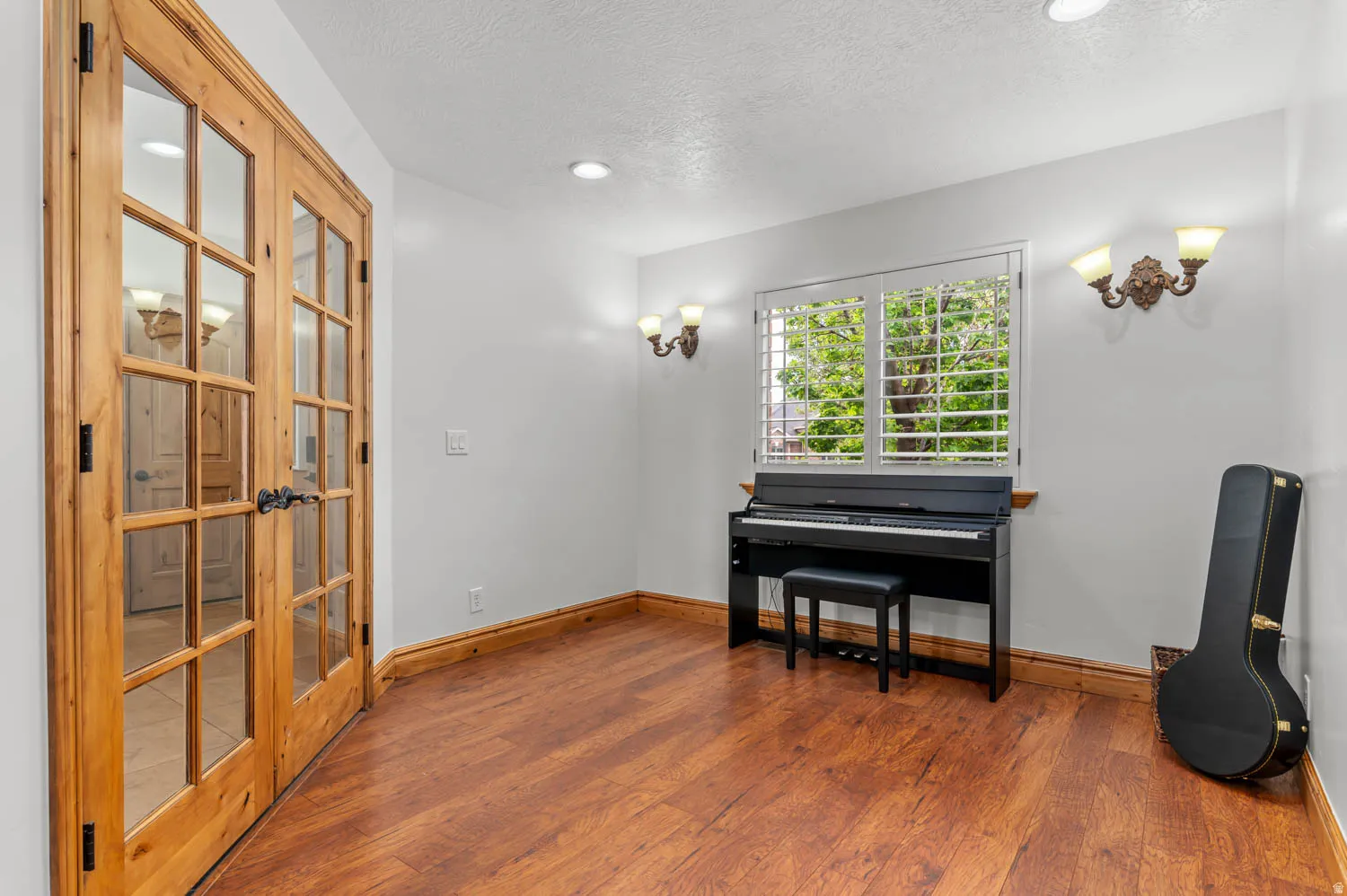 Living area with wood finished floors, a textured ceiling, french doors, and recessed lighting