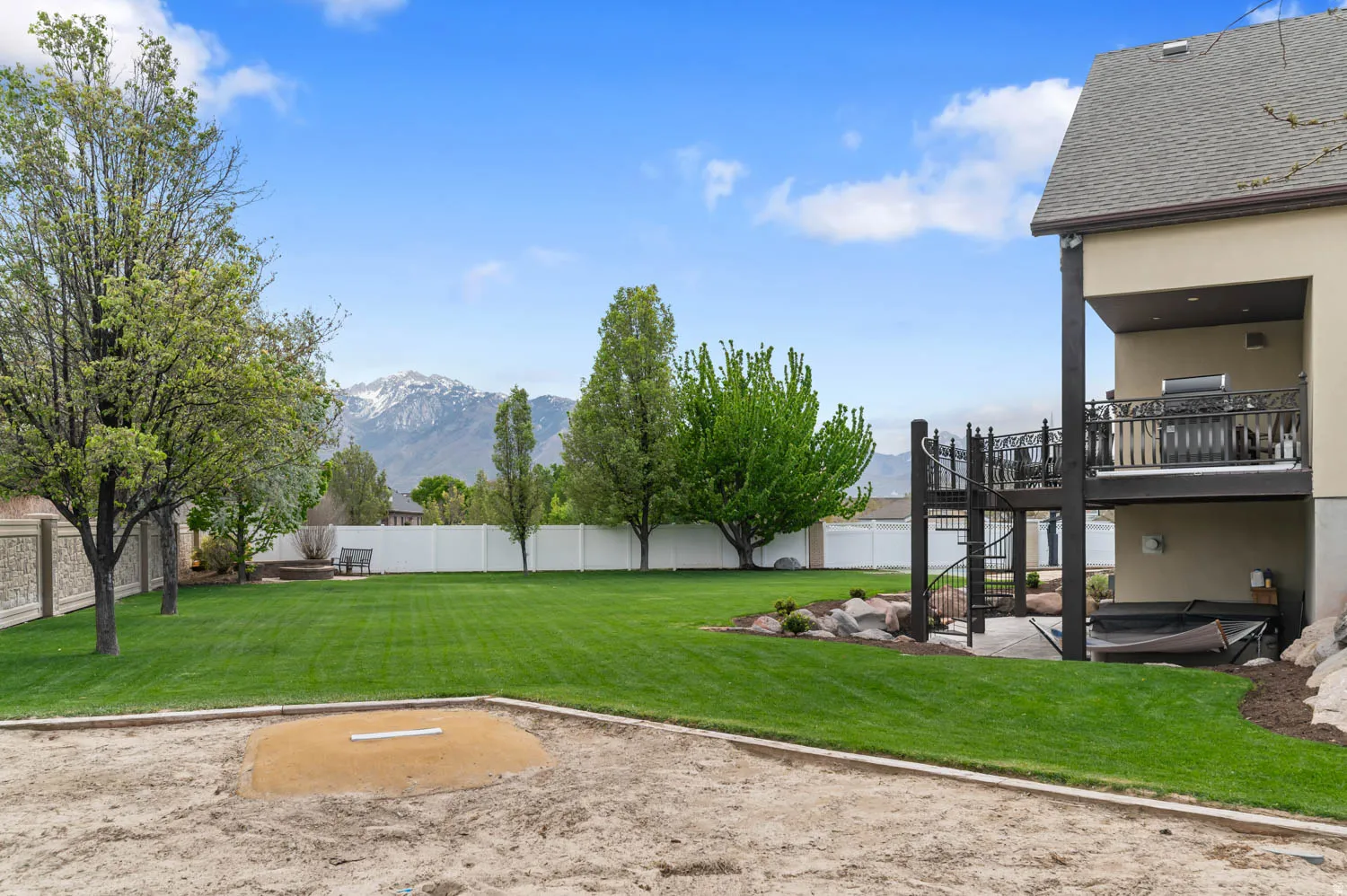 Fenced backyard with a deck with mountain view and a patio area