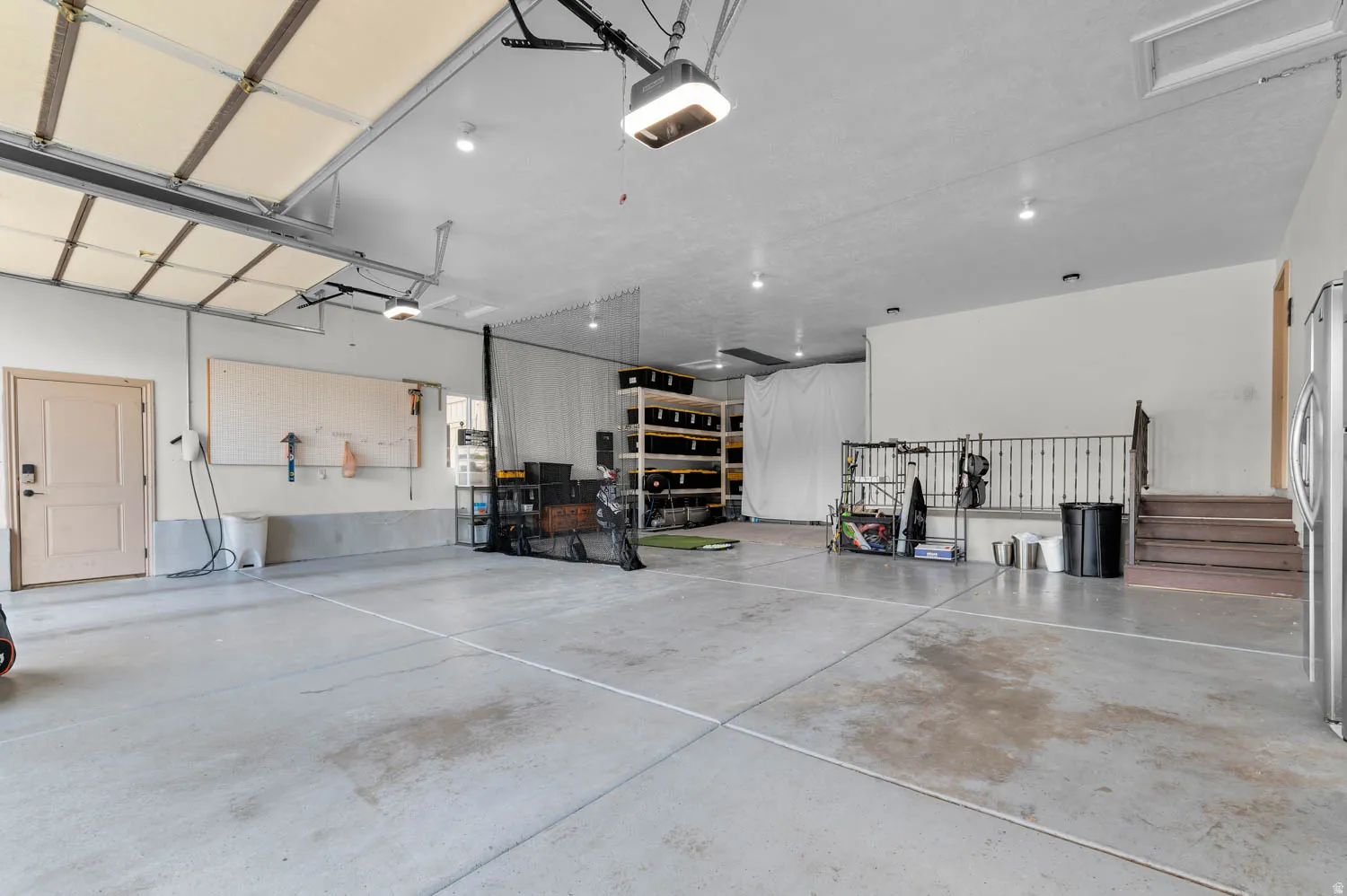 Garage with freestanding refrigerator and a garage door opener