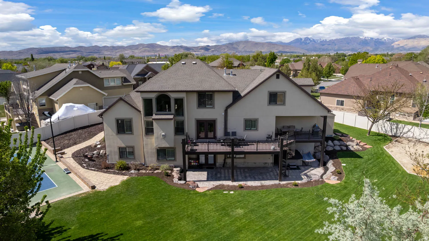 Back of property with stucco siding, a residential view, a fenced backyard, a mountain view, and a patio area