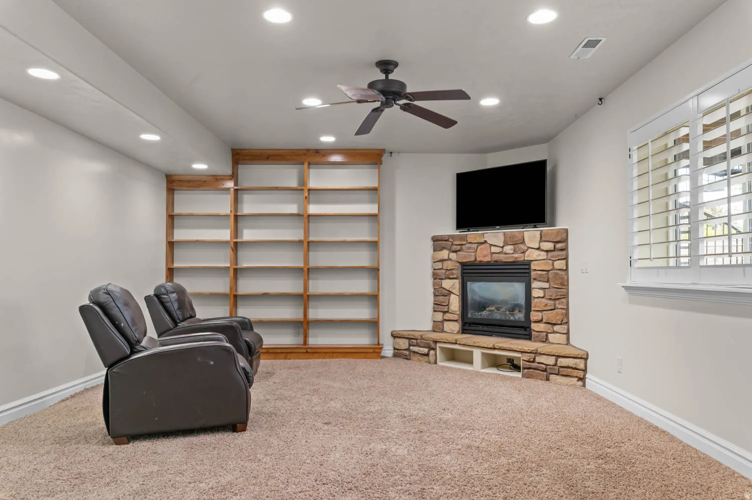 Unfurnished room featuring a ceiling fan, carpet flooring, recessed lighting, and a fireplace
