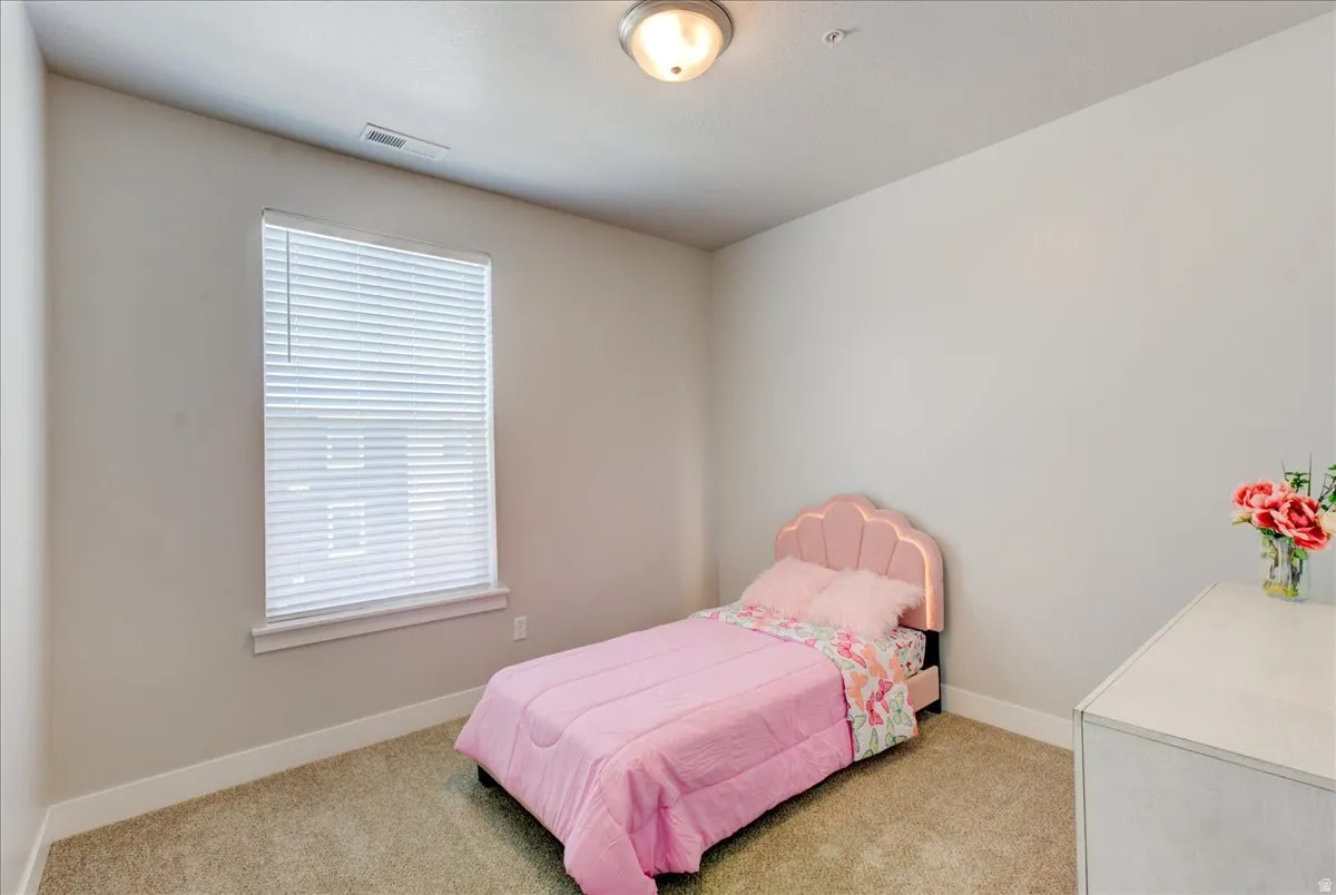 Bedroom with baseboards and light carpet