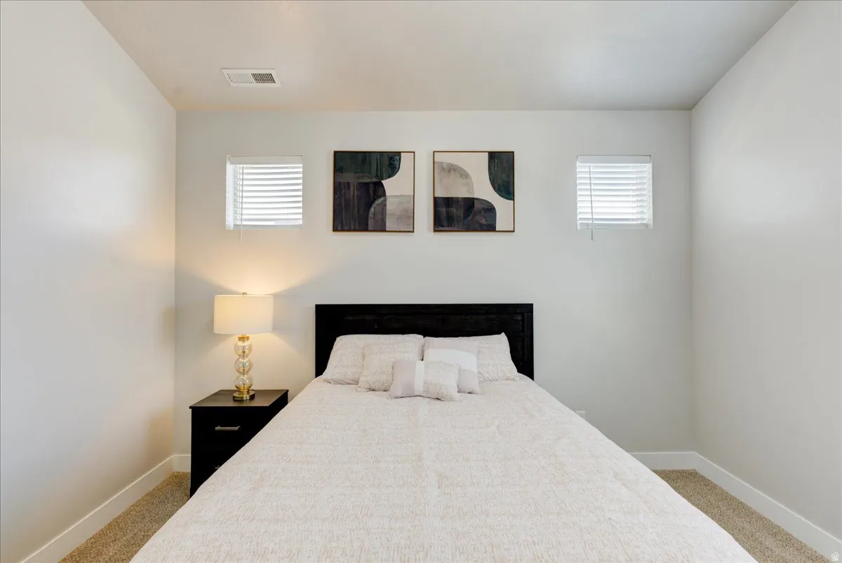 Bedroom featuring light colored carpet and baseboards