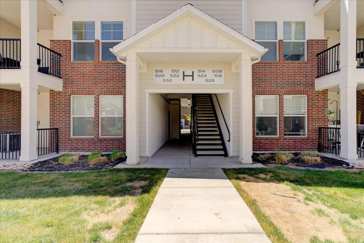 Property entrance with a lawn, brick siding, and board and batten siding
