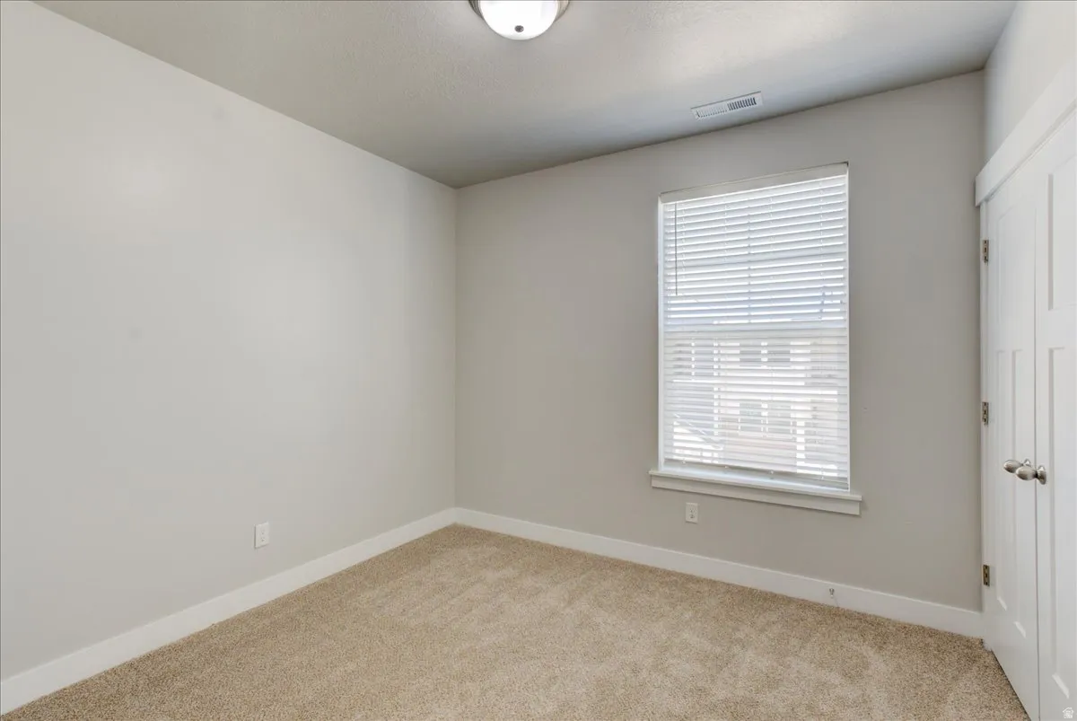 Unfurnished bedroom with light colored carpet and a closet