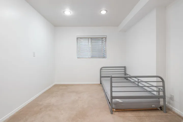 Unfurnished bedroom featuring baseboards and light carpet