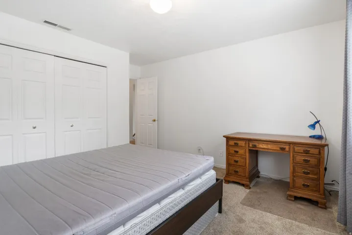 Bedroom featuring light colored carpet and a closet