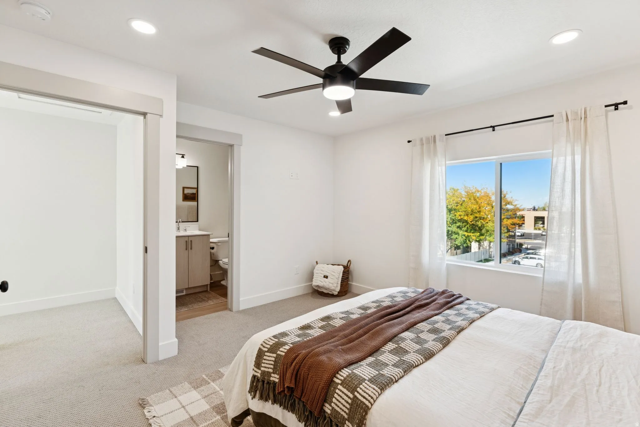 Bedroom with light carpet, recessed lighting, ceiling fan, and ensuite bath