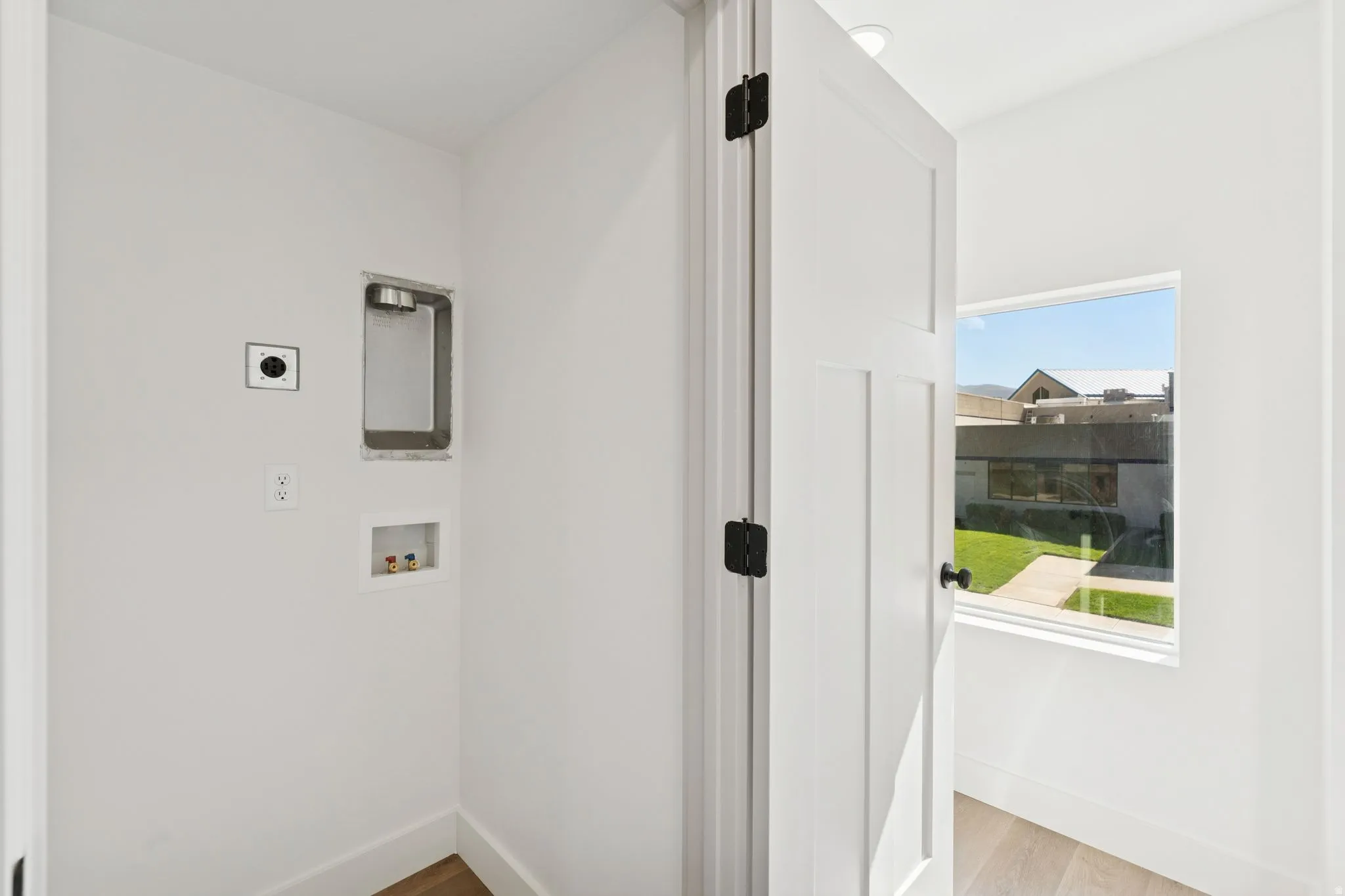 Laundry area with washer hookup and light wood-style flooring