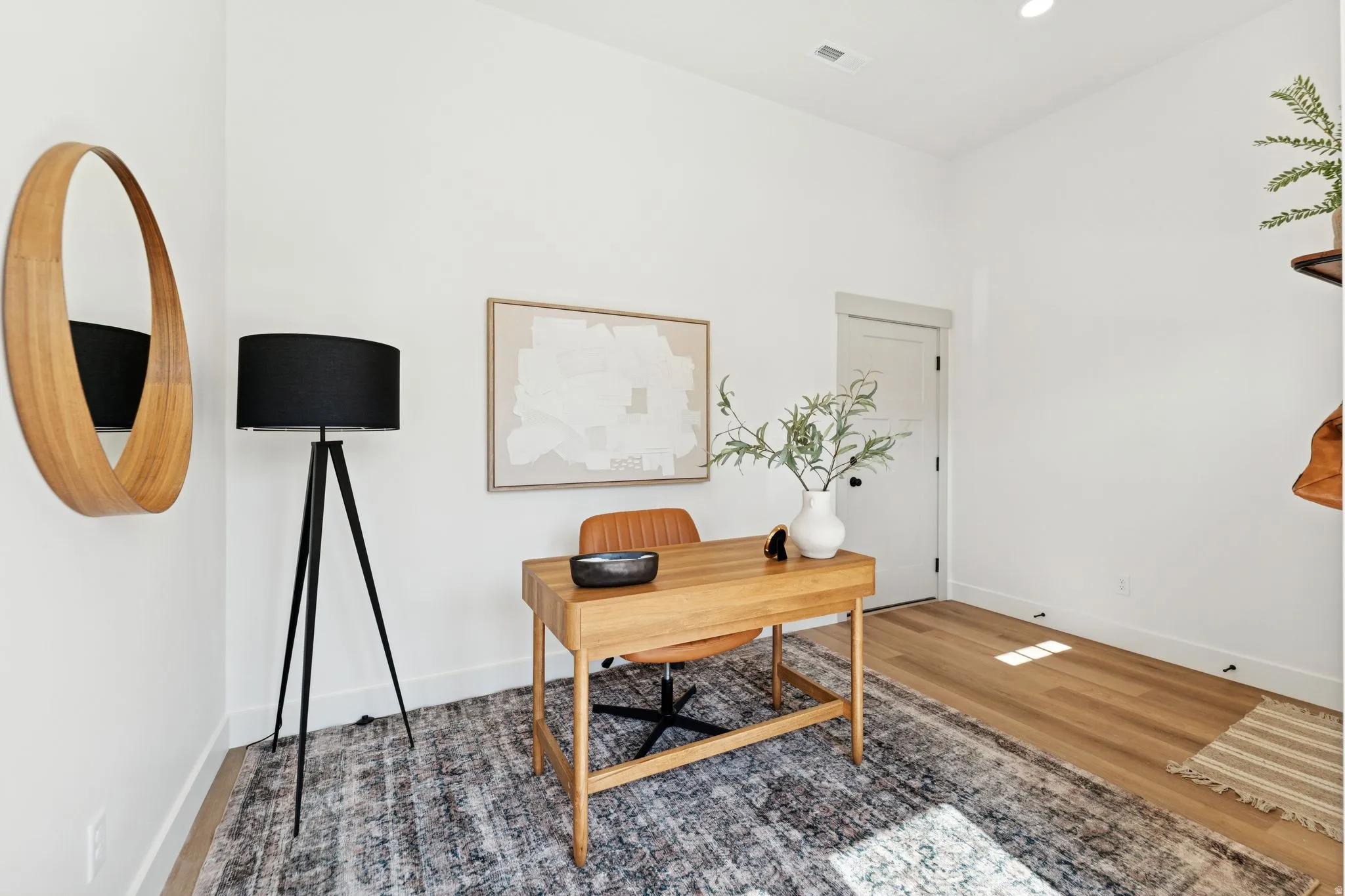 Office with wood finished floors and recessed lighting