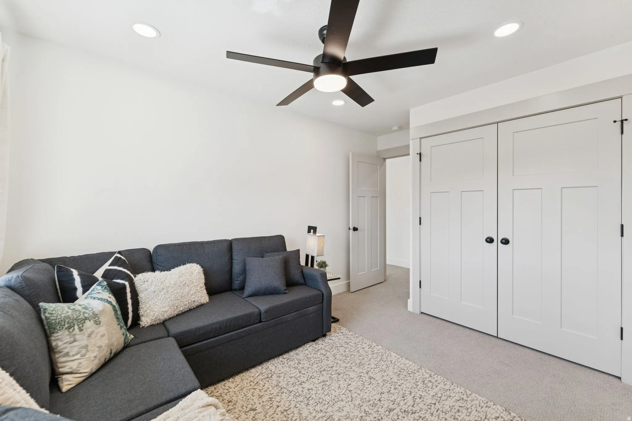 Living room featuring light carpet, ceiling fan, and recessed lighting