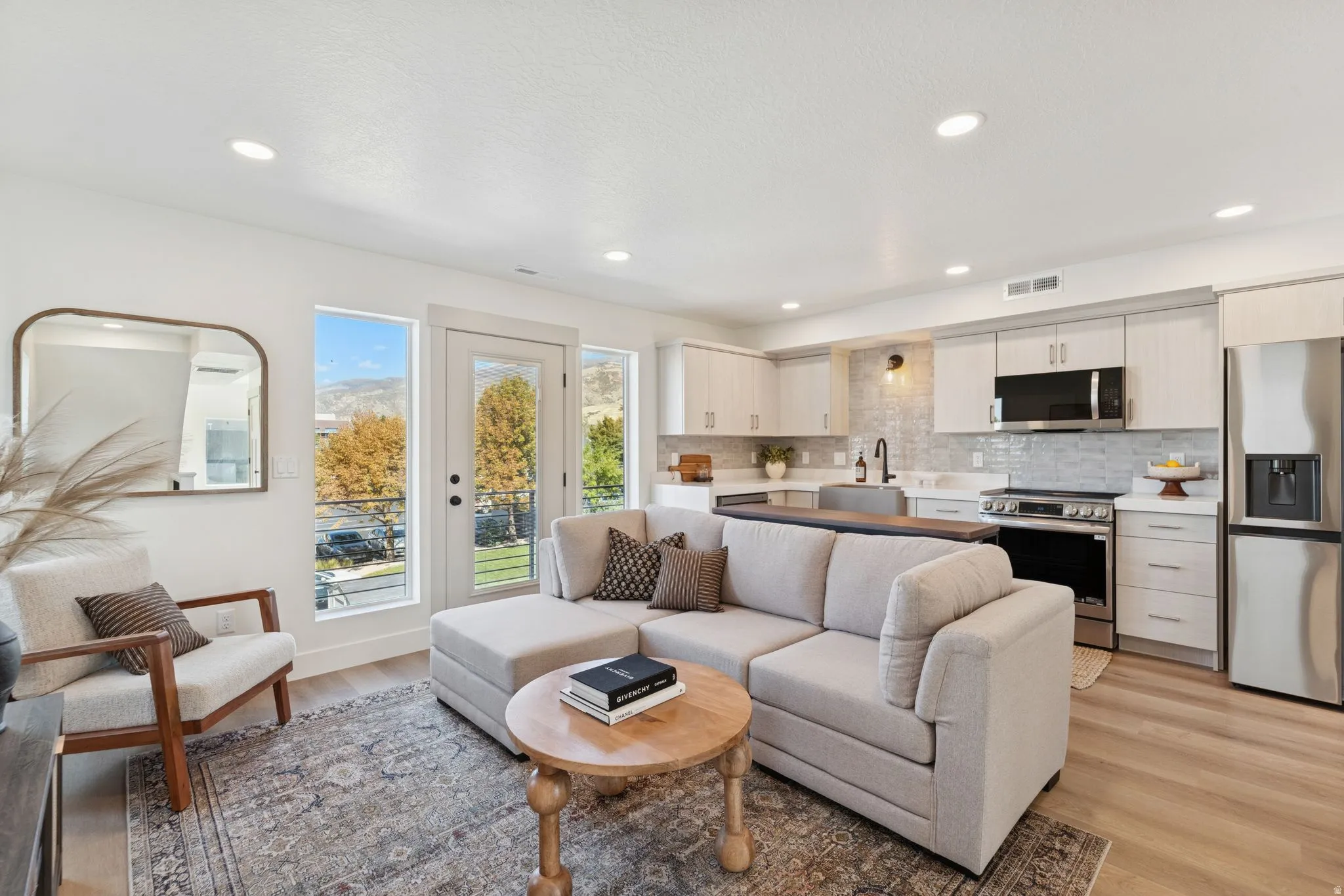 Living area with light wood finished floors and recessed lighting
