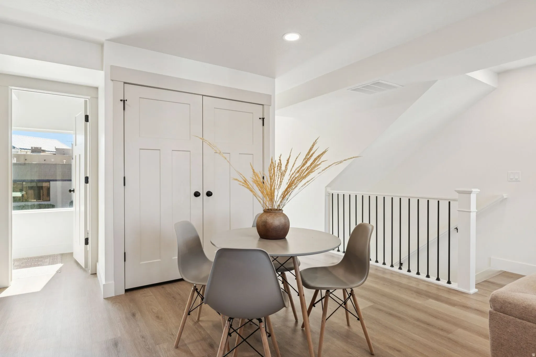 Dining room with light wood-style floors and recessed lighting