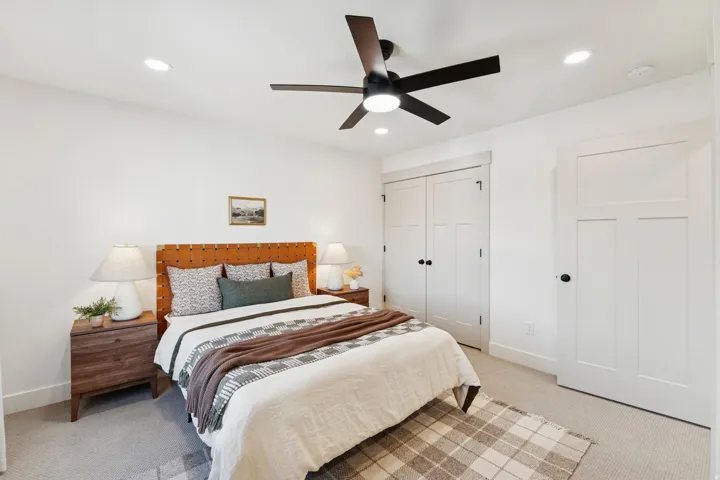 Bedroom with light carpet, a ceiling fan, a closet, and recessed lighting