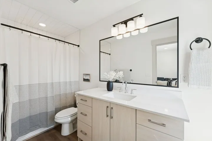 Full bath with vanity, dark wood-type flooring, and recessed lighting