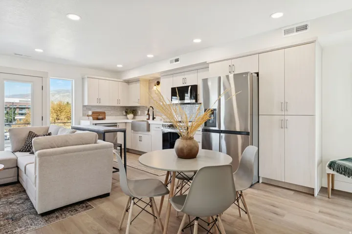 Kitchen with stainless steel appliances, light countertops, light wood finished floors, recessed lighting, and tasteful backsplash