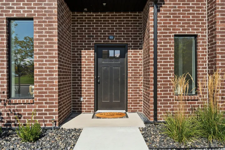 Doorway to property featuring brick siding
