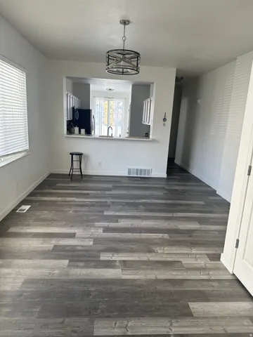 Unfurnished dining area with dark wood finished floors and baseboards