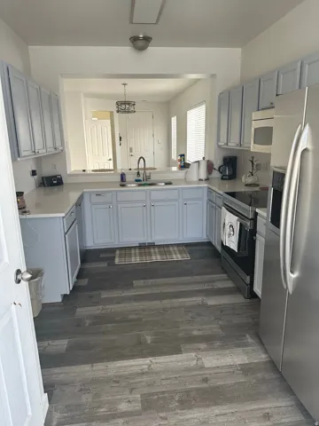 Kitchen with light countertops, gray cabinets, and stainless steel appliances