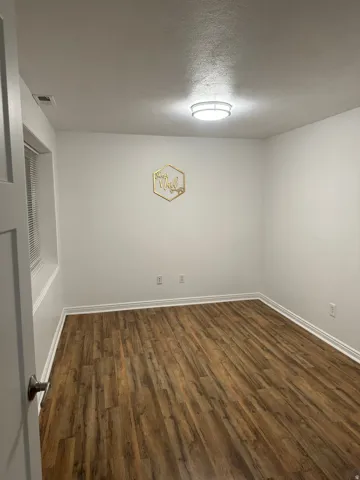 Spare room with dark wood-style floors and a textured ceiling