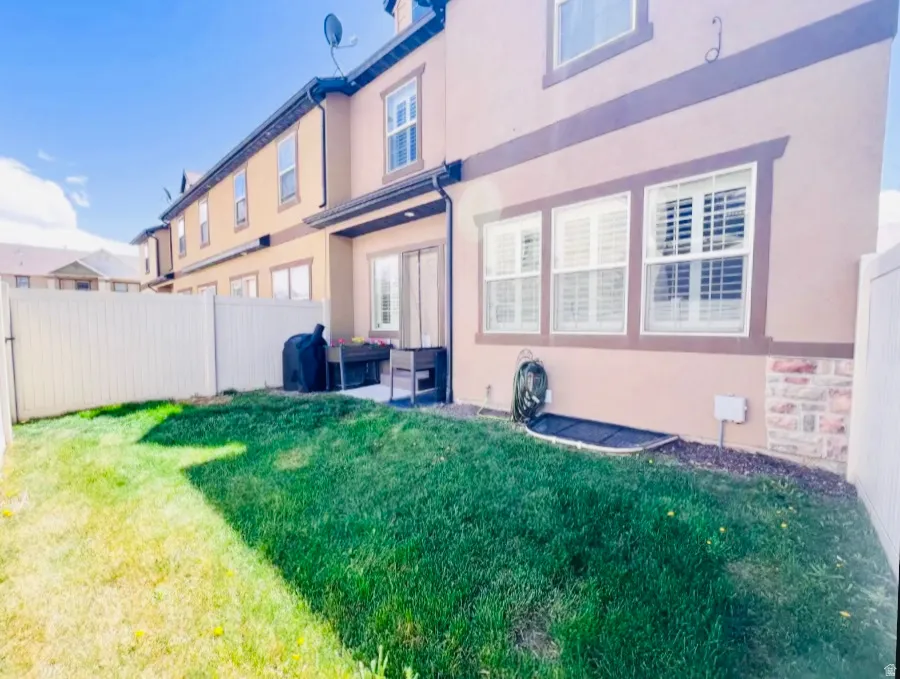 Rear view of property featuring a fenced backyard, stucco siding, and a patio