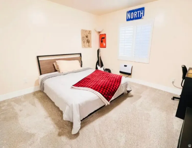 Bedroom featuring light colored carpet and baseboards