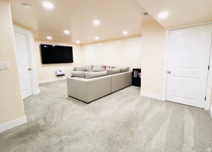 Living area featuring light colored carpet and recessed lighting