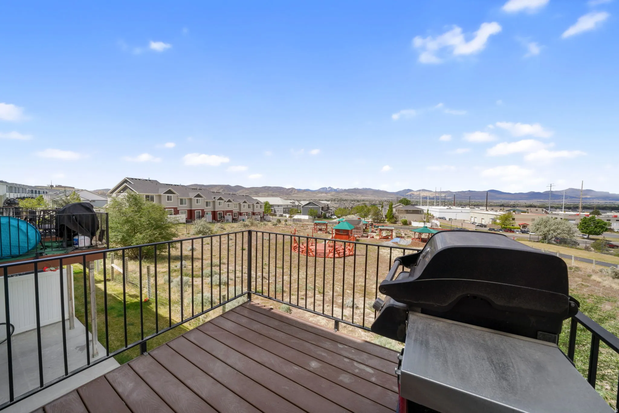 Wooden deck with area for grilling, a residential view, and a mountain view