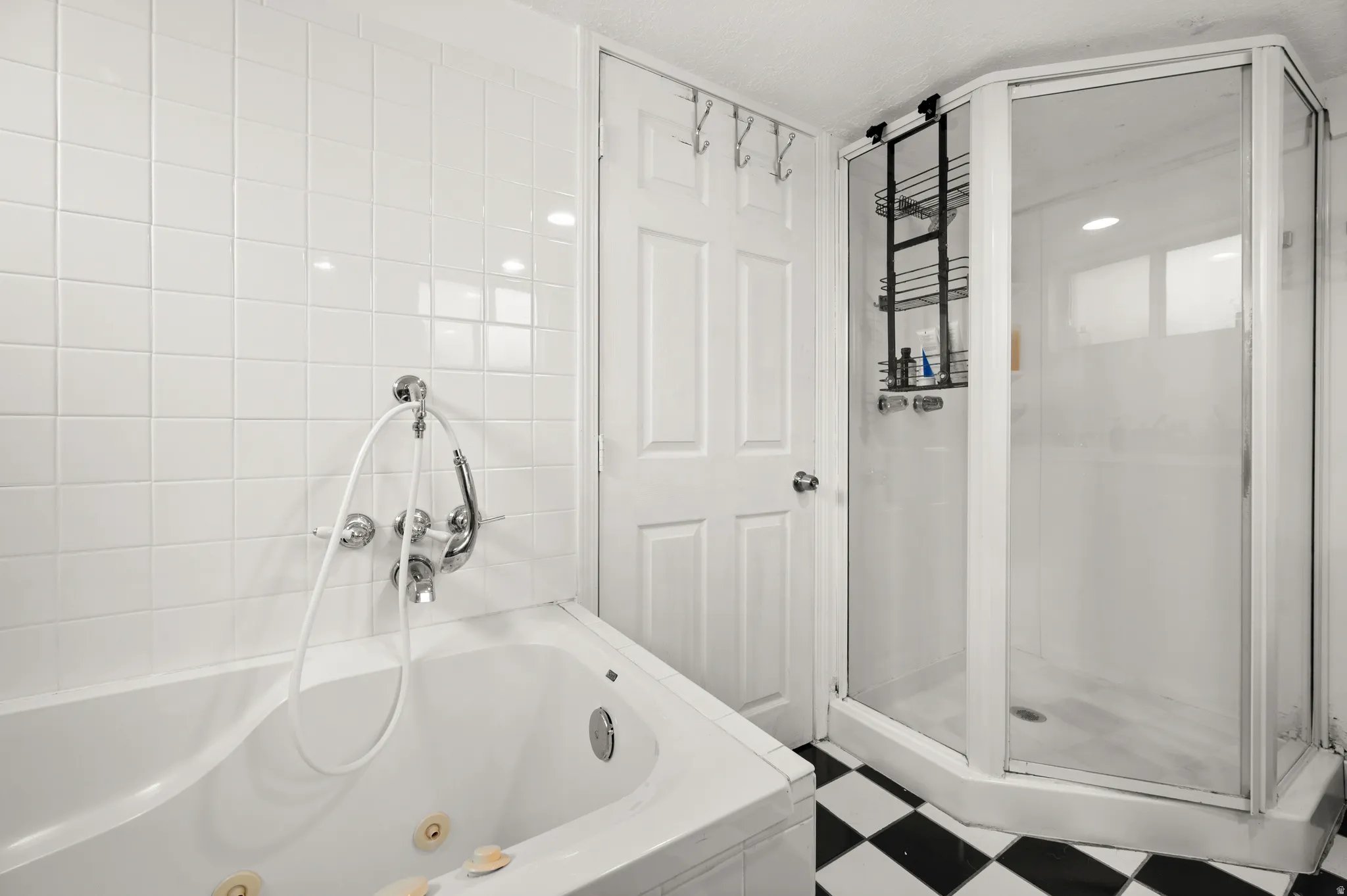 Full bath with a stall shower, tile patterned floors, and a jetted tub