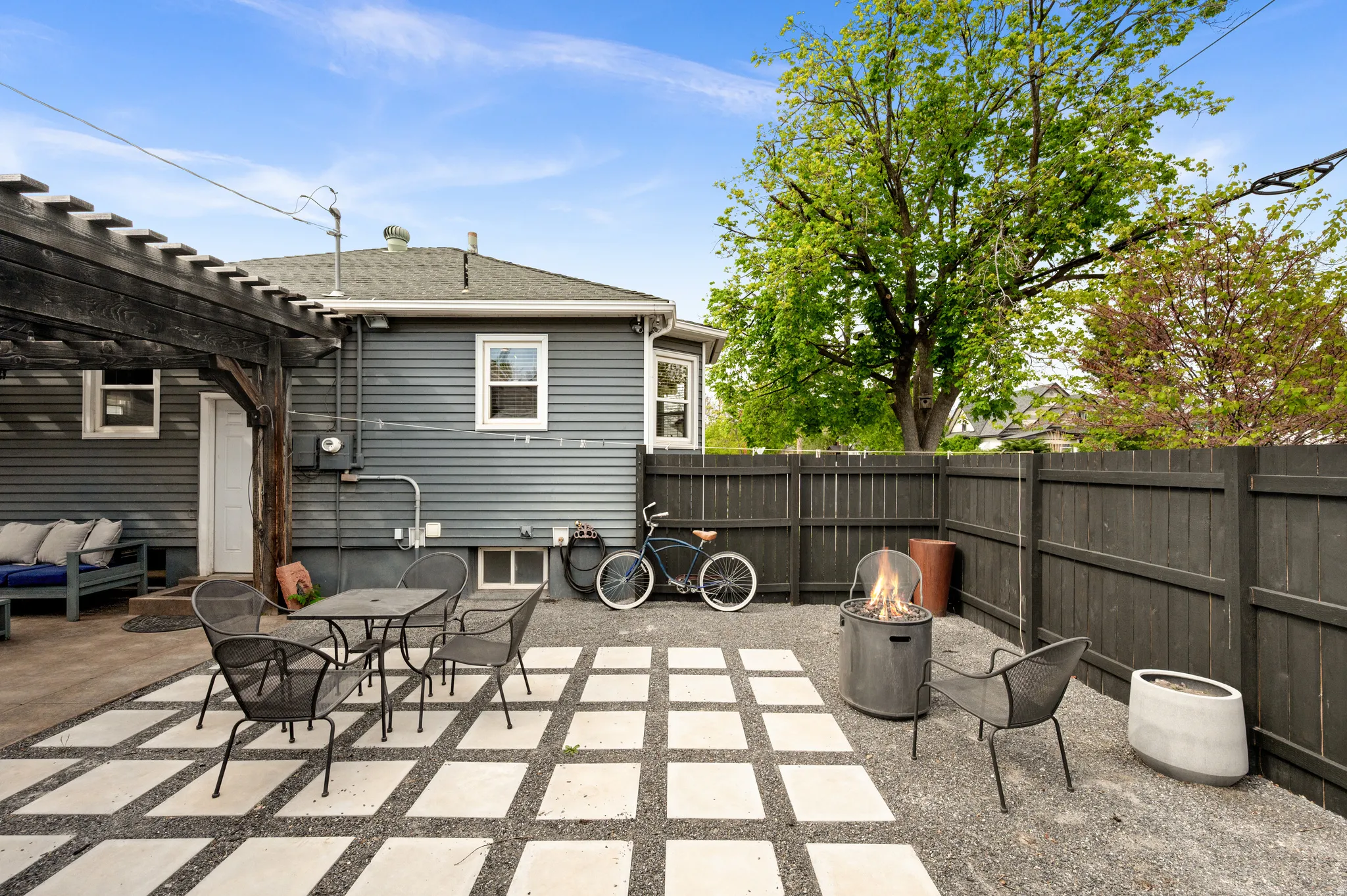 Fenced backyard with a patio, a fire pit, outdoor dining area, and a pergola