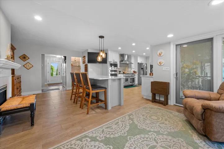 Kitchen featuring a peninsula, a kitchen bar, light wood-style flooring, and open floor plan
