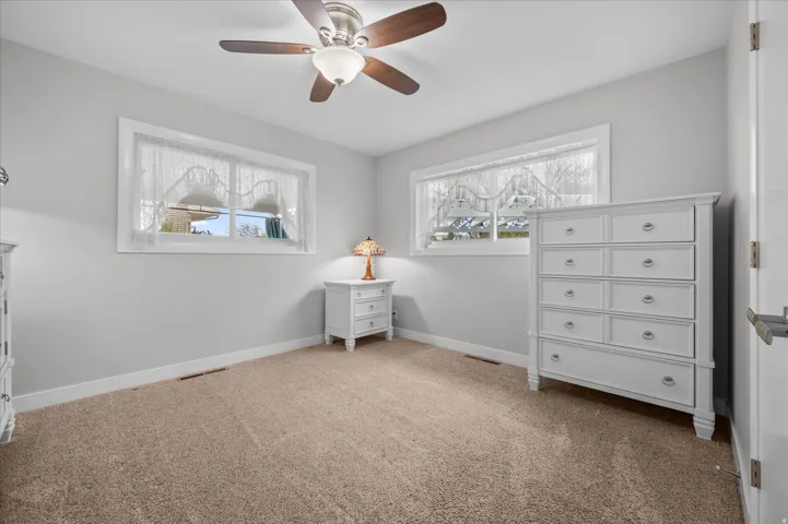 Carpeted bedroom with baseboards and ceiling fan