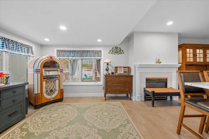 Bedroom with a high end fireplace, light wood-style flooring, and recessed lighting