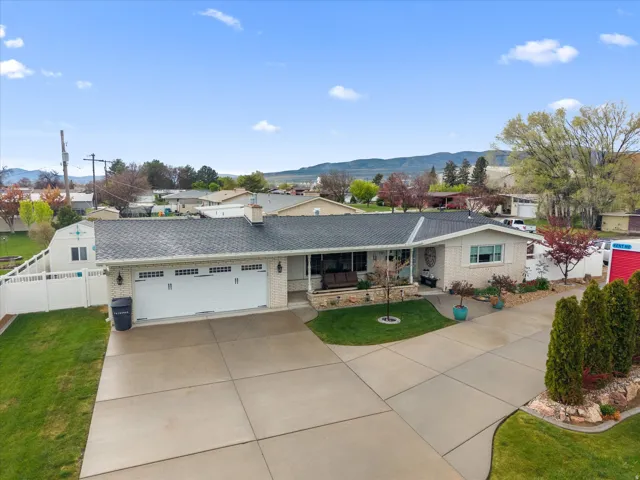 Ranch-style house with a mountain view, an attached garage, driveway, and brick siding