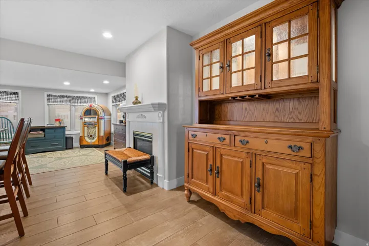 Interior space featuring light wood finished floors, a glass covered fireplace, and recessed lighting