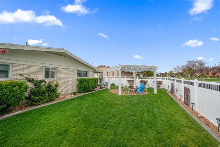 Fenced backyard with a pergola and a patio area
