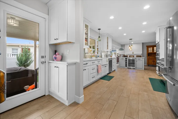 Kitchen with glass fronted cabinets, pendant lighting, and white cabinets
