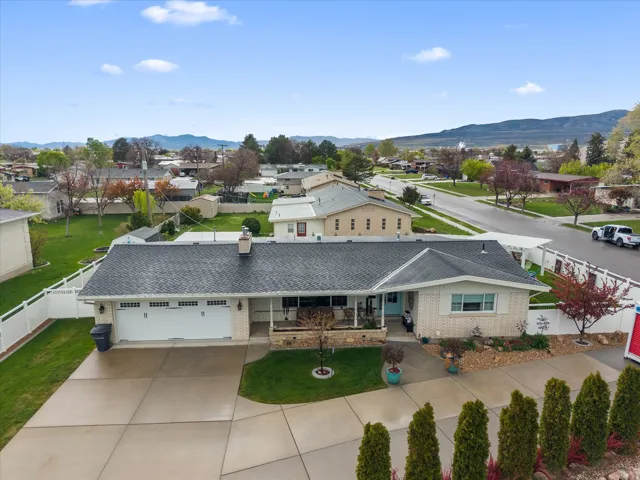 View of front facade featuring brick siding, a garage, a mountain view, and concrete driveway