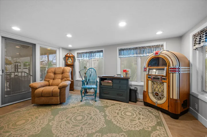 Living area with light wood-type flooring and recessed lighting
