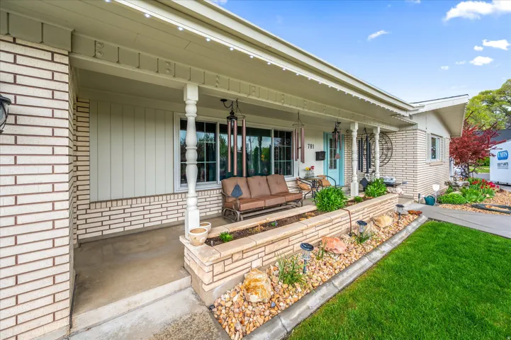 Doorway to property with covered porch and brick siding