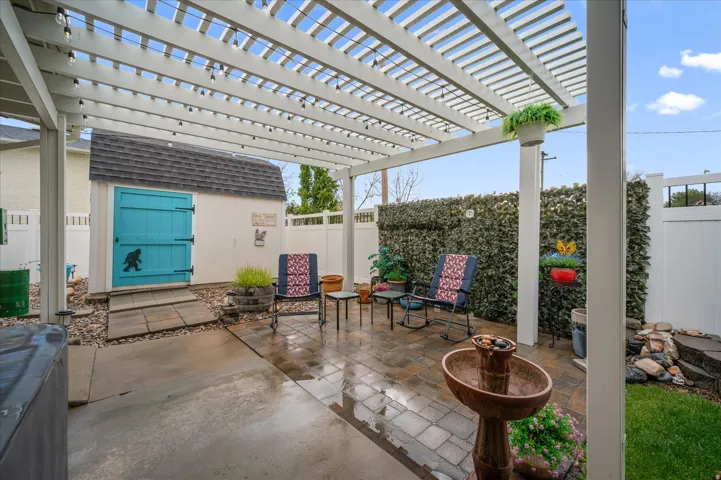 Fenced backyard with a pergola, a patio area, and a shed