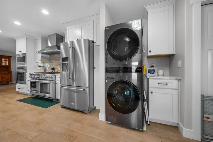 Main level living! Laundry area with stacked washing machine and dryer and recessed lighting. Appliances included.